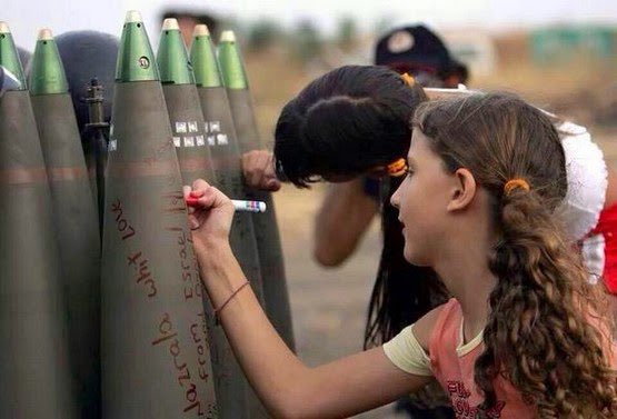 طالبات مدرسة صهاينة يكتبن على صواريخ في أحد المواقع العسكرية الصهيوية خلال حرب تموز/يوليو عام 2006.